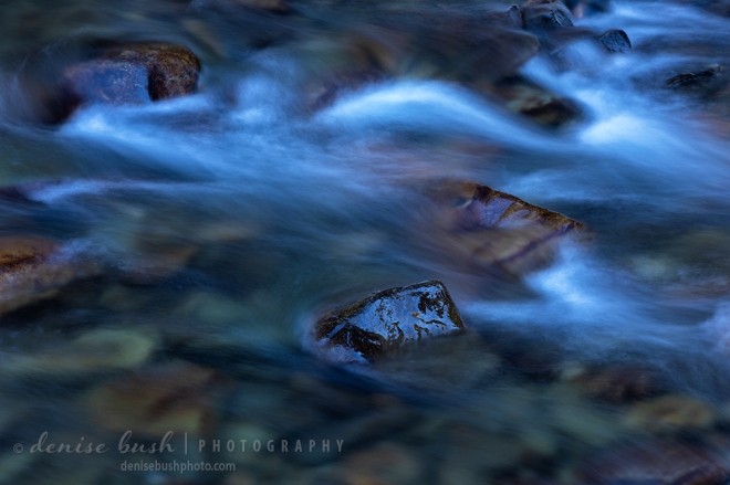Water rushes downstream through a rocky river in Colorado.