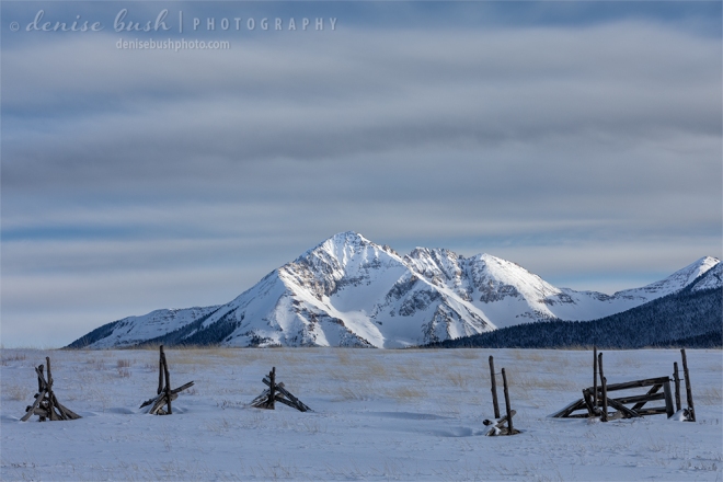 An old broken-down fence provides an interesting foreground in this winter mountain scene.