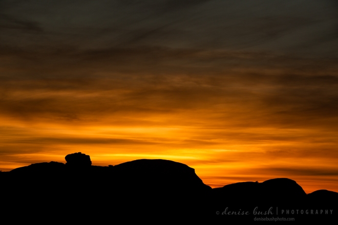 A beautiful sunset creates an interesting silhouette photograph with a rocky impression.