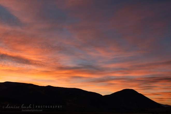 A beautiful sunrise greets the morning over a mountain silhouette.